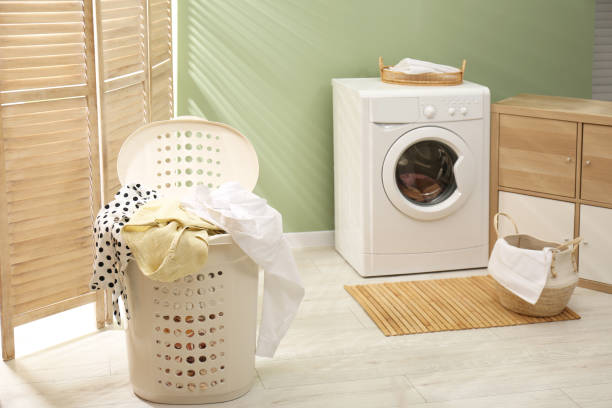 istock Laundry basket filled with clothes in bathroom. Space for text 1797307261