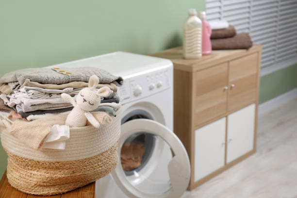 istock Laundry basket with baby clothes and toy on table in bathroom. Space for text 1797308351