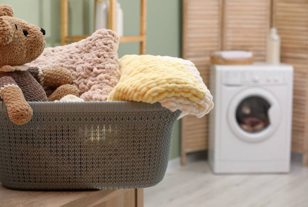 istock Laundry basket with soft blankets and toy in bathroom, closeup. Space for text 1797308894