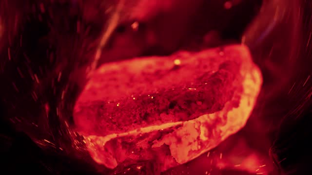 Red hot glowing ingot placed on an anvil and hit with a blacksmith's hammer to flatten and prepare for folding. Sparks flying and smoking. stock video