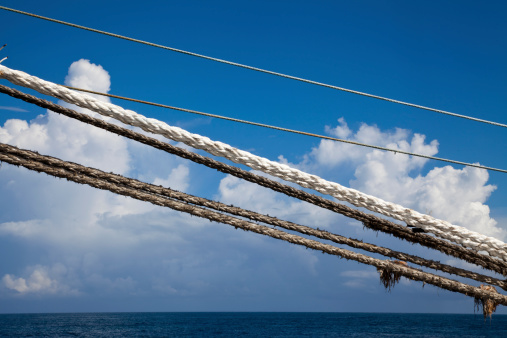 Ropes and strings over the ocean securely tying a big ship