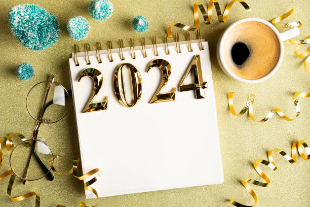 2024 new year resolutions on desk. 2024 goals list with notebook, coffee cup, festive decorations on golden background. resolutions, plan, goals, checklist, idea concept. new year 2024 resolutions. copy space - determination new years eve list aspirations imagens e fotografias de stock