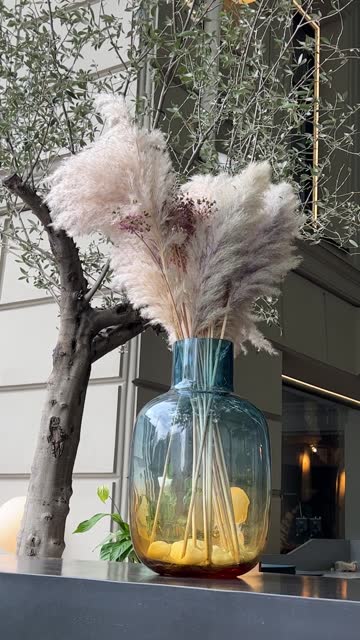 Decorative fluffy pampas grass in a glass jar vase.