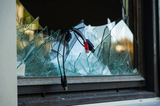 istock Computer cables hanging out of a broken window after a break in and theft.. 1797355740