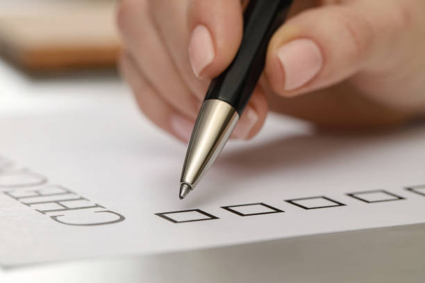istock Woman filling Checklist at light grey table, closeup 1797385358