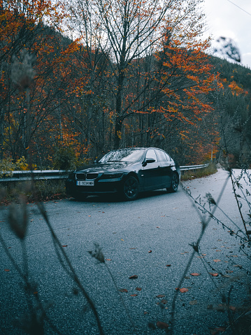 Parked car on the road with beautiful autumn colors in the background.