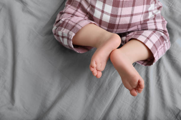 istock Little baby in pajamas on bed, top view. Space for text 1797445852