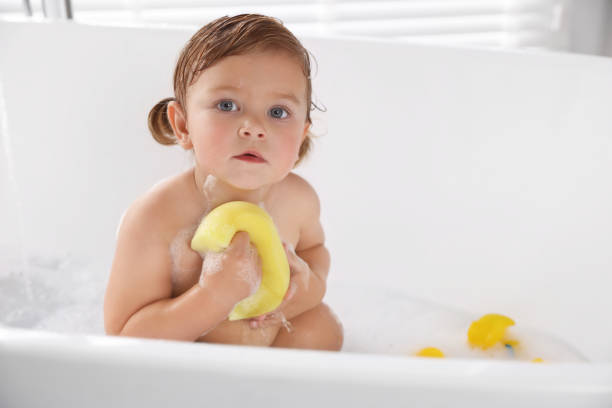 istock Cute little girl with bast wisp taking bubble bath. Space for text 1797449574