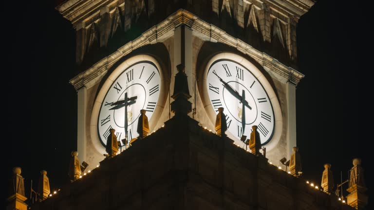 Day to night time lapse illuminated large tower clock on the top of Palace of Culture and Science PKiN in Warsaw city