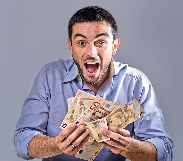 istock Exultant Young Man holding Banknotes 179751518