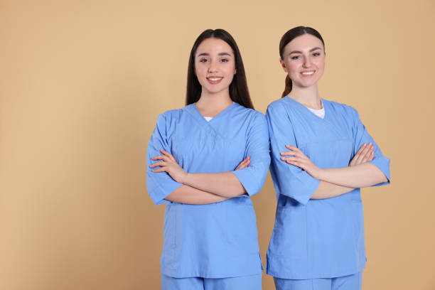 istock Nurses in medical uniforms on light brown background, space for text 1797535363
