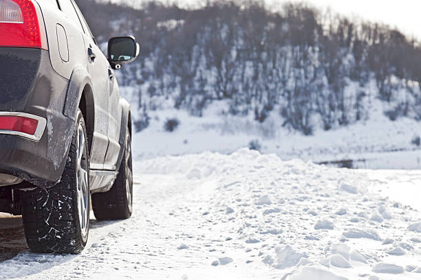 Car driving up a hill in the snow stock photo