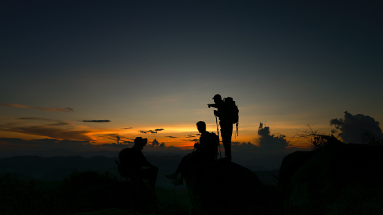 Silhouette hiker traveler on rock at cliff of mountain,adventure travel lifestyle ,summer vacation
