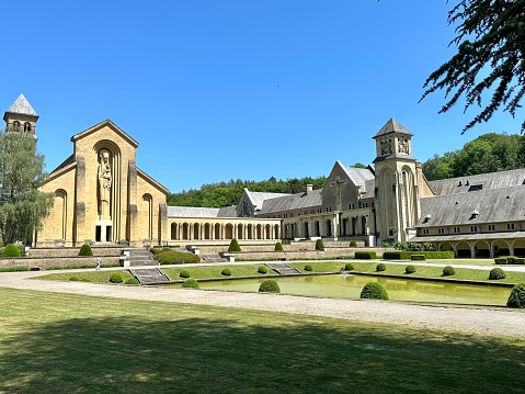 Modern part of medieval Cistercian monastery. Statue of the Virgin Mary carved from stone, towers, blue sky
