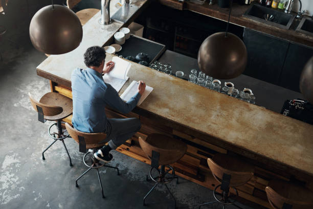 istock Cafe business owner, man and documents for reading, back or top view for planning, stock or inventory. Coffee shop, entrepreneur or writing with paperwork, data analysis or thinking in finance review 1797615973