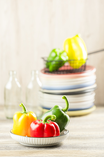 Red, yellow, and green peppers placed on the table.