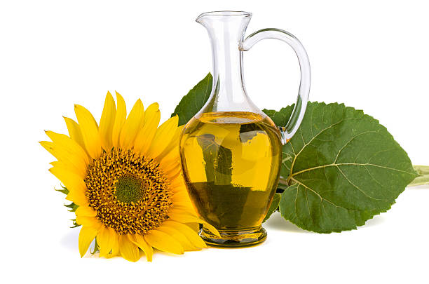 sonnenblume und öl in glas-karaffe - sunflower seed oil stock-fotos und bilder