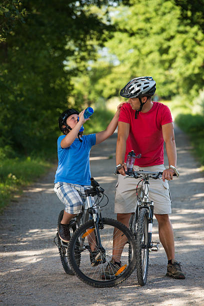 istock Father and Son cycling through park 179770817