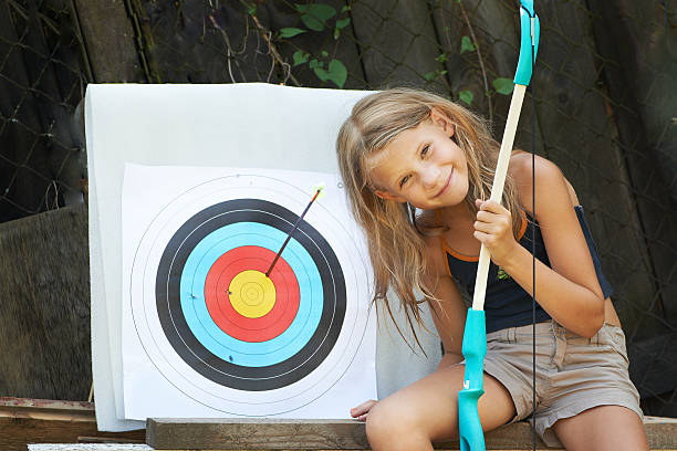 dziewczyna z kokardą i sportu cel - child outdoors bow horizontal zdjęcia i obrazy z banku zdjęć