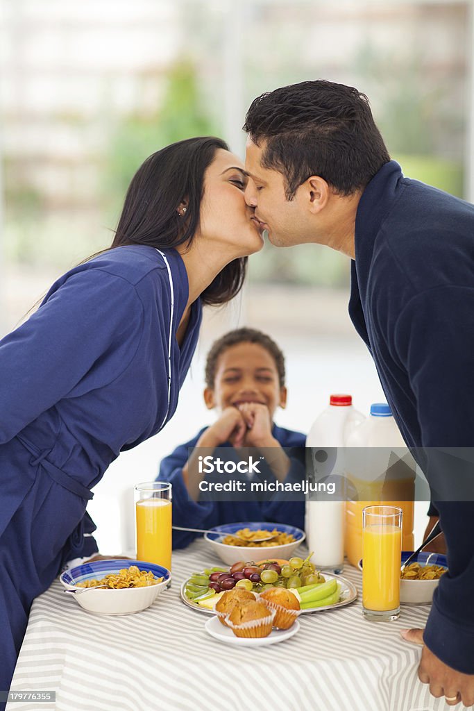 笑う少年ている場合は、ご両親には朝食にキスをする - きまり悪さのロイヤリティフリーストックフォト