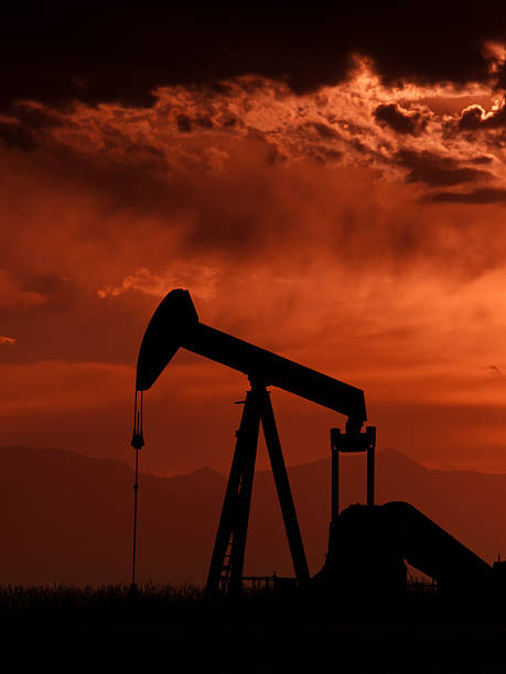 Pumpjack A pumpjack silhoutte with dramatic sunset. goldco prices stock pictures, royalty-free photos & images