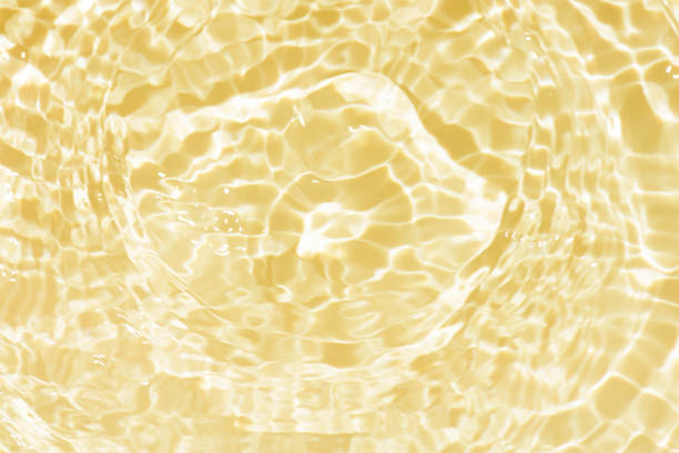 istock Defocus blurred transparent yellow colored clear calm water surface texture with splashes reflection. Trendy abstract nature background. Water waves in sunlight with copy space. Gold watercolor shine 1797828278