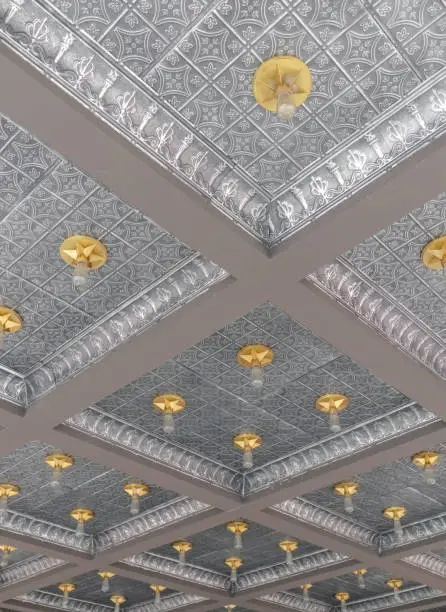 Extended view of silver tin ceiling with gold bulb fixtures
