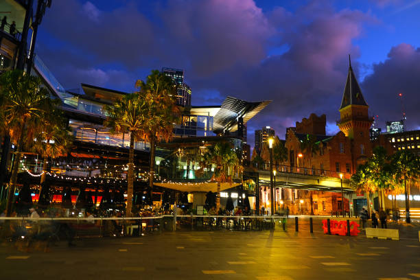 People at night in Circular Quay, an international passenger shipping port, public piazza and tourism precinct and heritage area in Sydney, New South Wales.