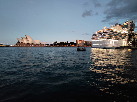 Cruise ship moored at Circular Quay, an international passenger shipping port, public piazza and tourism precinct and heritage area in Sydney, New South Wales. In the distance, the iconic Opera House.