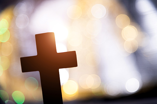 Backgrounds of religious cross and defocused lights.
