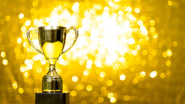 istock Golden trophy on shiny yellow background 1797924139