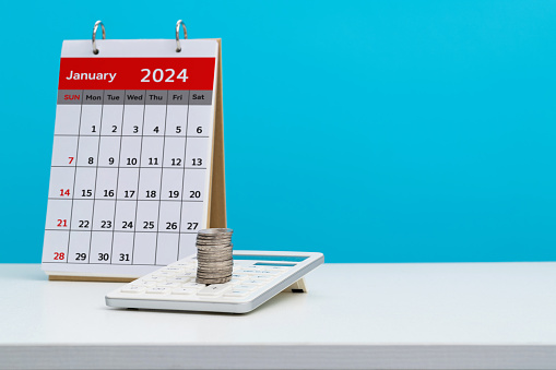 Calendar january 2024 with calculator and coins on the table