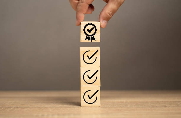 istock Man put the certificate icon on wood cube into the right icon. ISO certificate guarantee quality control in the marketing, finance and business industry. Satisfaction concept. 1797934812