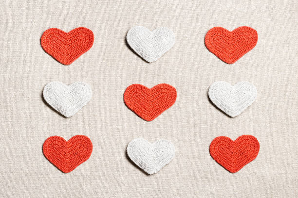 istock Valentines day geometric pattern from different knit hearts valentine white and red, handmade colored crochet heart on table, handmade gift for romance holiday, symbol of love. Top view, 1798002142