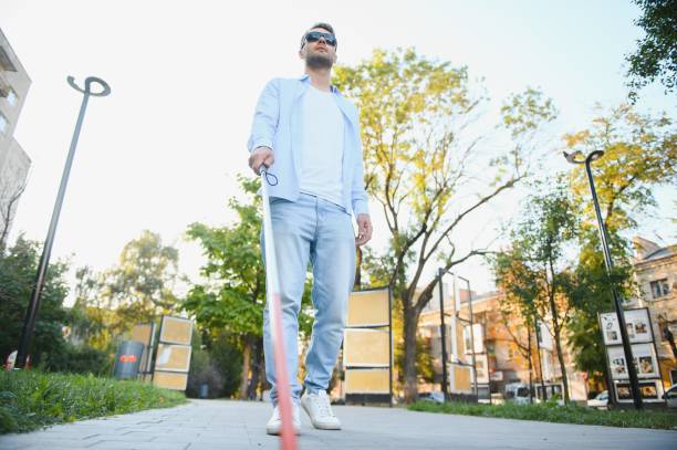 istock Young handsome blinded man walking with stick in town 1798006869
