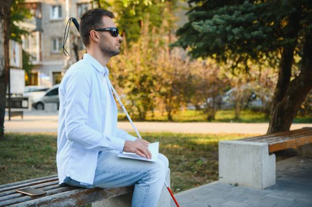 hombre ciego leyendo tocando libro braille - outdoors book reading accessibility fotografías e imágenes de stock