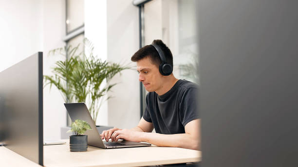 istock Modern office businessman working on a computer. Portrait of a successful Latin software engineer working on a laptop at his desk. Diverse workplace with professionals. 1798060721