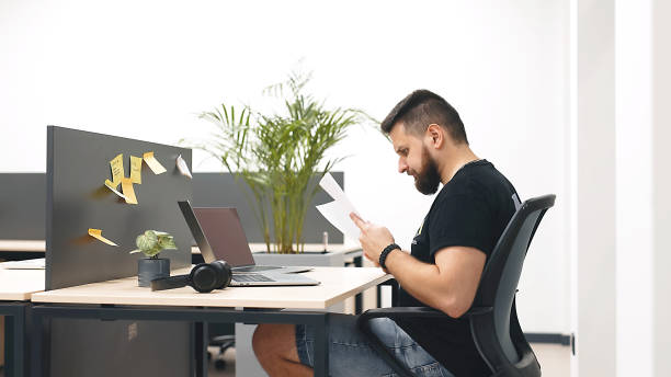 istock Modern office businessman working on a computer. Portrait of a successful Latin software engineer working on a laptop at his desk. Diverse workplace with professionals. 1798061237