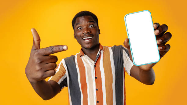 istock Young african man showing smartphone with isolated screen copy space 1798062833