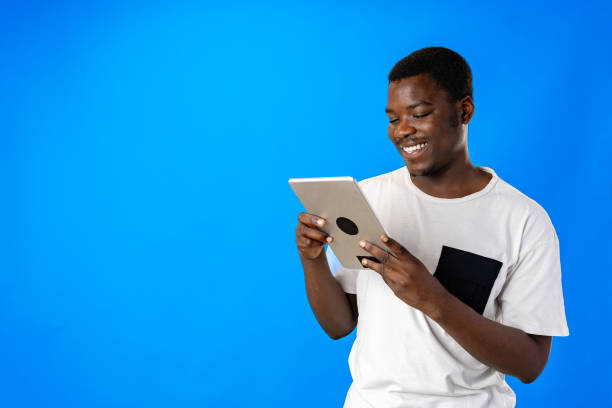istock Young african man using digital tablet against blue background 1798066661