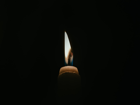 candle burning in a dark room