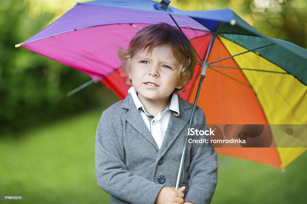 Petit mignon bébé garçon avec parasol coloré et des bottes, stationnement extérieur - Photo de 2-3 ans libre de droits