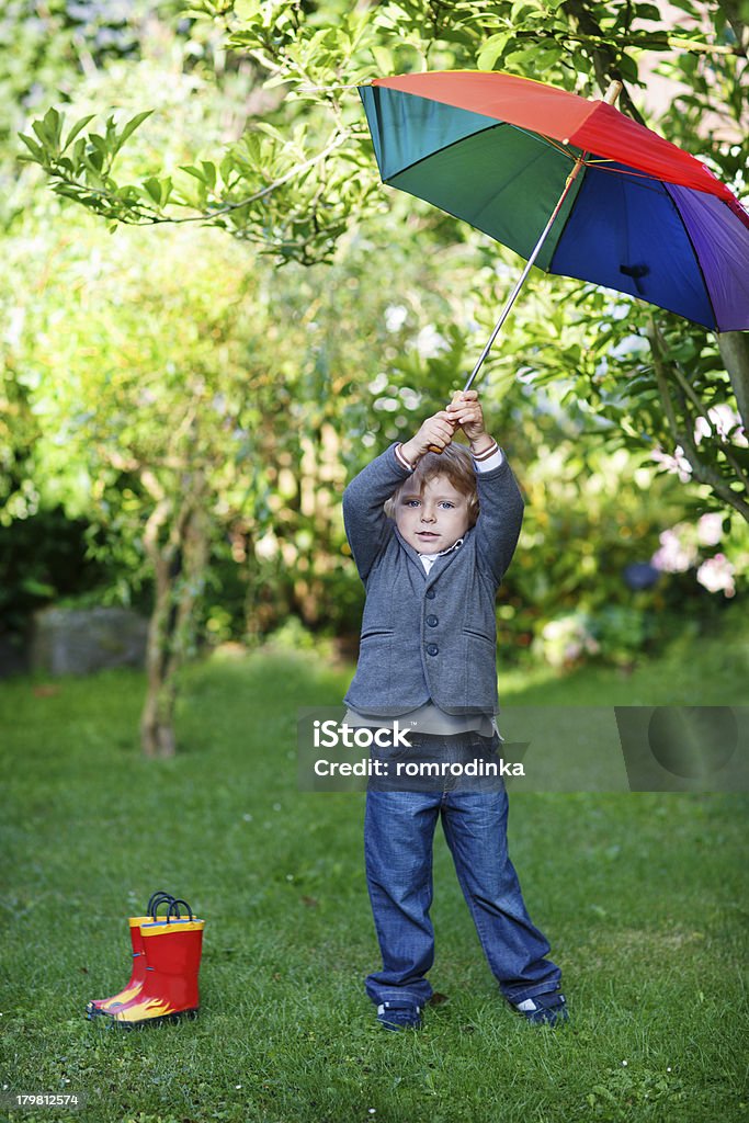 小さなかわいい幼児少年、カラフルな傘とブーツ、outdoo - 1人のロイヤリティフリーストックフォト