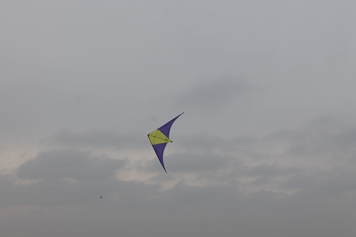 A colorful kite soaring in the cloudy sky