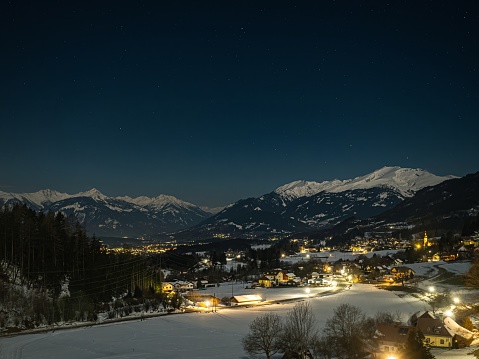 Night landscape with starry sky in the Alps, with street lights and villages in the valley, Millstatter See, Carinthia, Austria