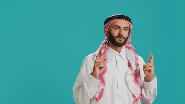 istock Muslim man holds fingers crossed 1798145543