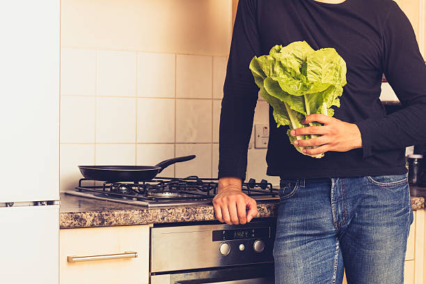 istock Man with head of lettuce in kitchen 179814609