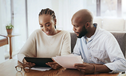 Couple, tablet and bills in home for budget, financial portfolio and mortgage loan. African man, woman and documents for digital banking, review investment and savings of taxes, insurance and policy