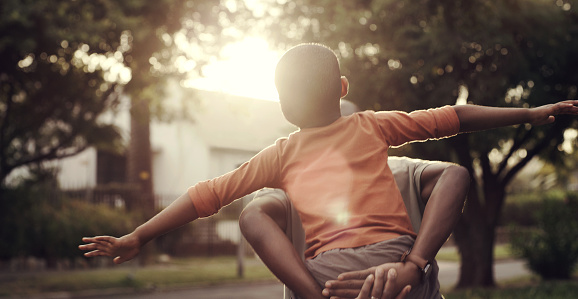 Piggyback, flying and a child with a parent in nature for bonding, fun and playing together. Summer, back and a boy, kid or father carrying while playing with freedom, family and in a park on weekend