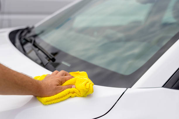 Man cleaning his car with a cloth